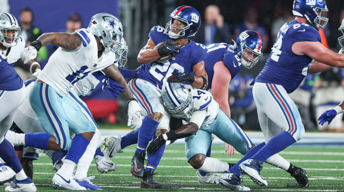 Giants running back Saquon Barkley (26) is tackled by Cowboys safety Markquese Bell (14) during the first half at MetLife Stadium.